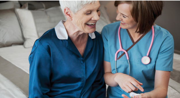 A nurse and a patient smiling at one another