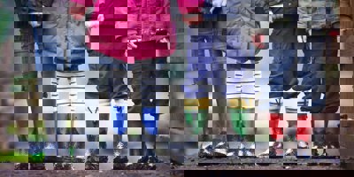 Four children wearing coats and muddy wellington boots